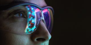 Frau mit Brille vor einem Hologramm