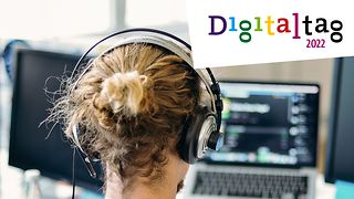 Junger Mann mit Kopfhörer sitzt am Laptop und spielt ein Onlinegames