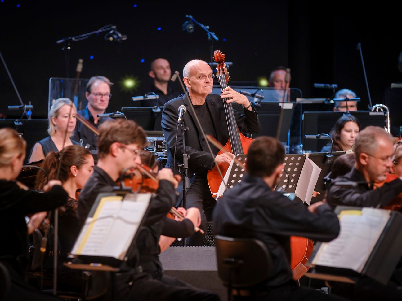 Das Bild zeigt den Jazz-Bassisten Lars Danielsson inmitten des Beethoven Orchester Bonn.