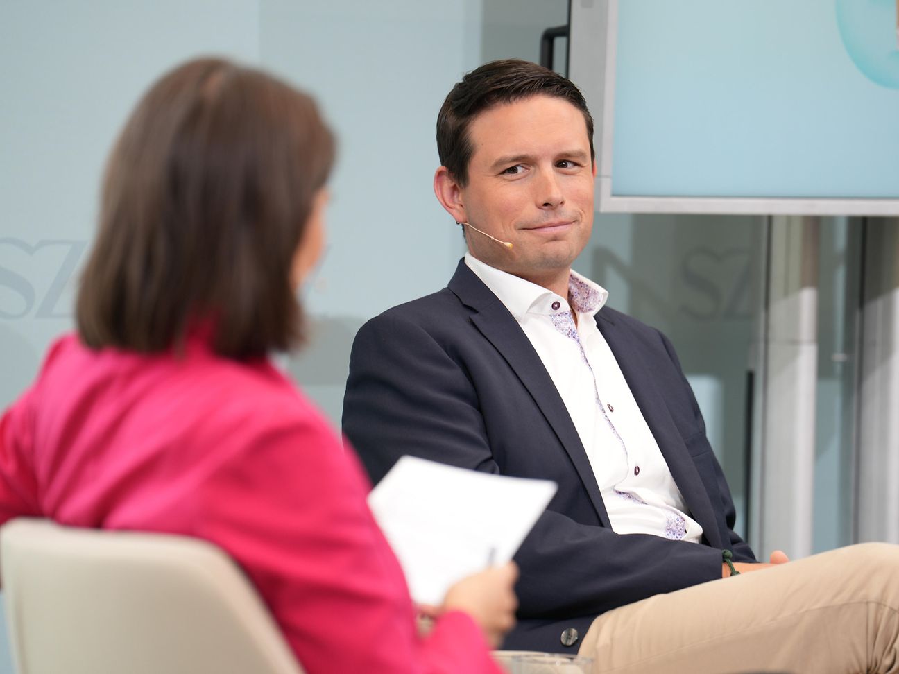 Interview-Situation: Frau mit brünetten Haaren von hinten und Benjamin Springub von vorne. 