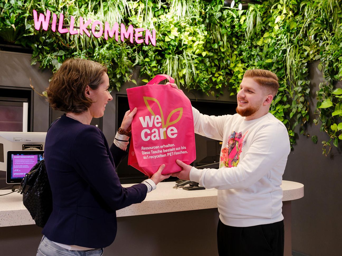 A man giving a woman a bag with the words we care written on it.