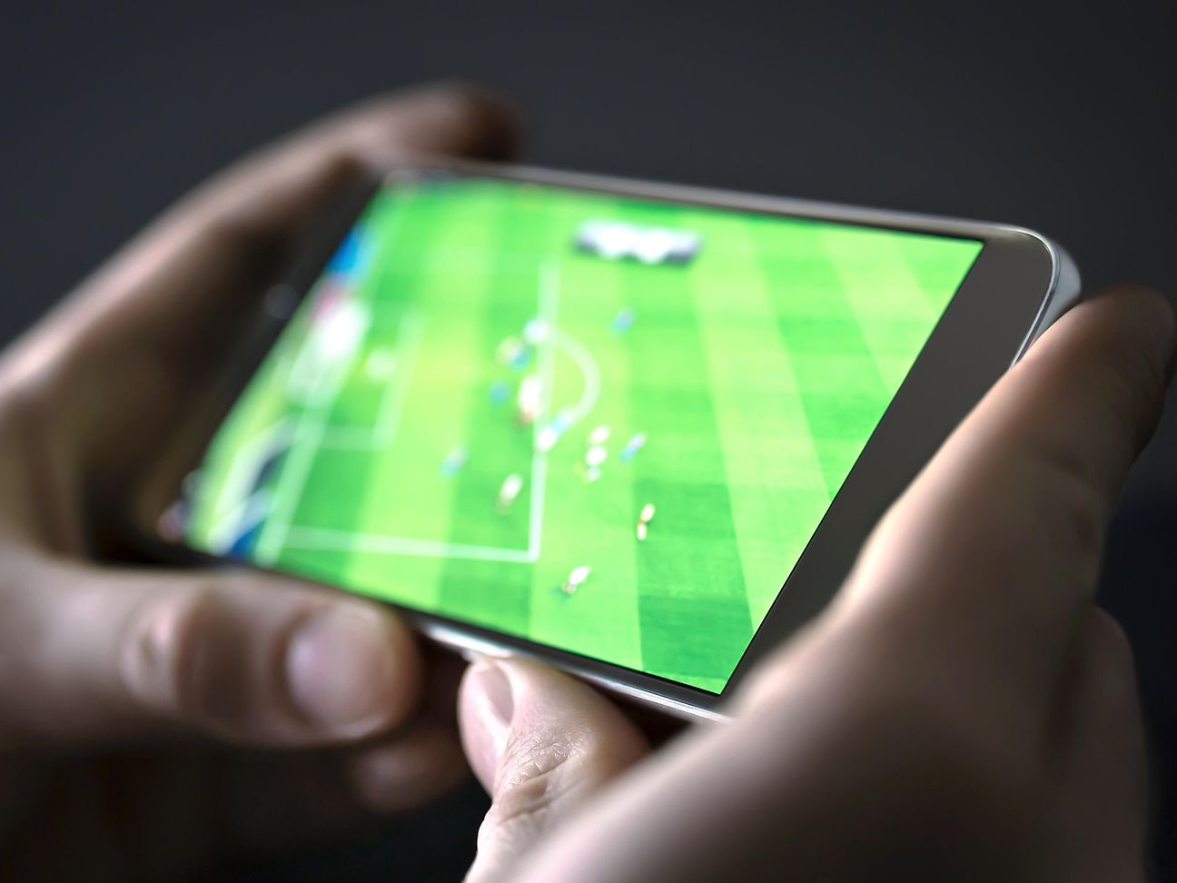Handy, auf dem ein Fußball-Spiel läuft.