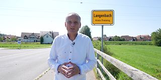 Pressesprecher Markus Jodl vor Ortsschild Langenbach.