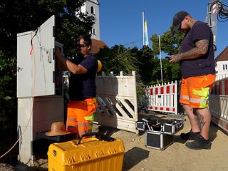 Telekom-Mitarbeiter bei der Arbeit auf der Baustelle beim Glasfaserausbau.