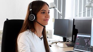 Jessica Nachtigall im Büro mit Headset.