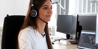 Jessica Nachtigall im Büro mit Headset.