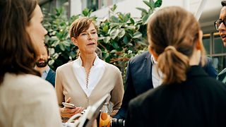 Several women speaking to each other in a courtyard