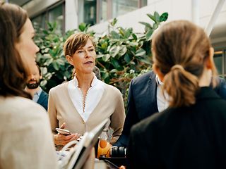 Several women speaking to each other in a courtyard