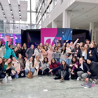 Ein große Gruppe von Frauen blickt lächelnd und jubelnd in die Kamera.