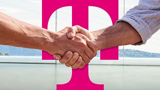 Two hands shaking in front of a large magenta Deutsche Telekom logo