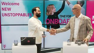 Two men shake hands during a virtual onboarding. 