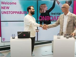 Two men shake hands during a virtual onboarding. 