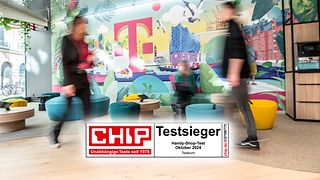 Wandmotiv des Flagship-Stores in Hamburg. Davor gehen zwei Kunden vorbei. Zusätzlich ist das Testsiegel von CHIP abgebildet. 