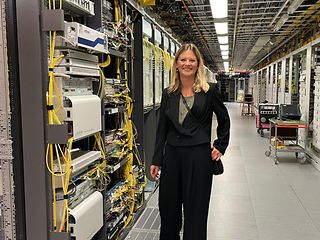  A woman stands in front of a large technical control cabinet