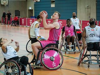 Learning by doing: the Bonn pros get a feel for sitting and moving around in a wheelchair.