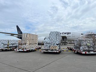 Loaded air freight pallet in the freight hall. A digital display documents the checking of the pallet dimensions.