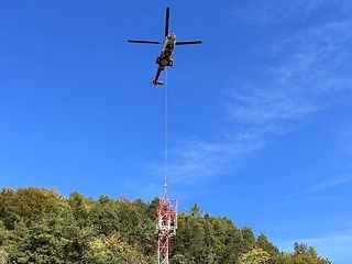 Der Helikopter platziert den Mobilfunkmast am Waldarand.