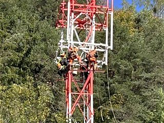 Das angeseilte Montage-Team installiert die Antennentechnik.