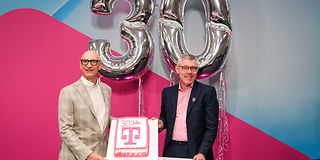 Tim Höttges and Christian Illek with cake and balloons for the 30th company aniversery.