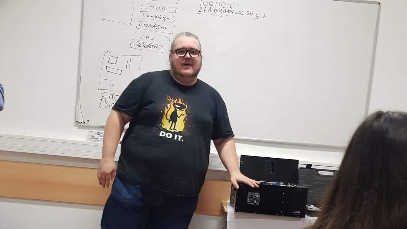 Ein Mann, neben ihm ein PC. Im Vordergrund eine ZuhörerinEin Mann, neben ihm ein PC. Im Vordergrund eine Zuhörerin