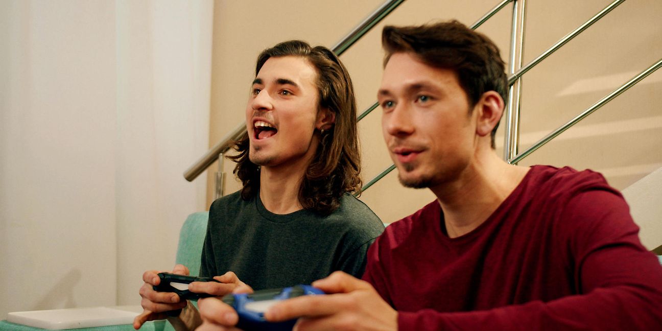 Zwei junge Männer schauen spielen ein Spiel über die Console