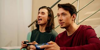 Zwei junge Männer schauen spielen ein Spiel über die Console