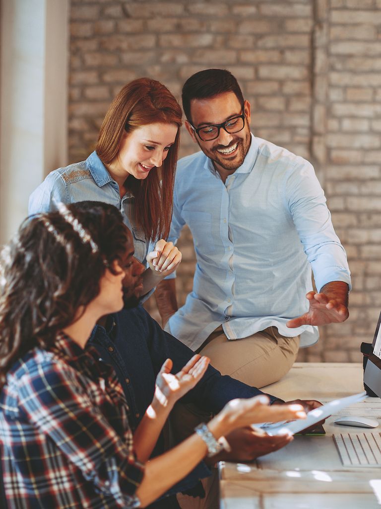 Four employees at a computer.