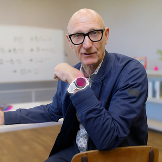 Tim Höttges zeigt die Smartwatch.