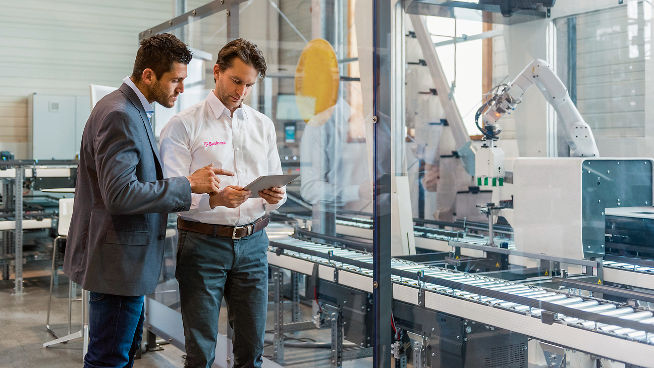 Two men with a tablet on the production line.