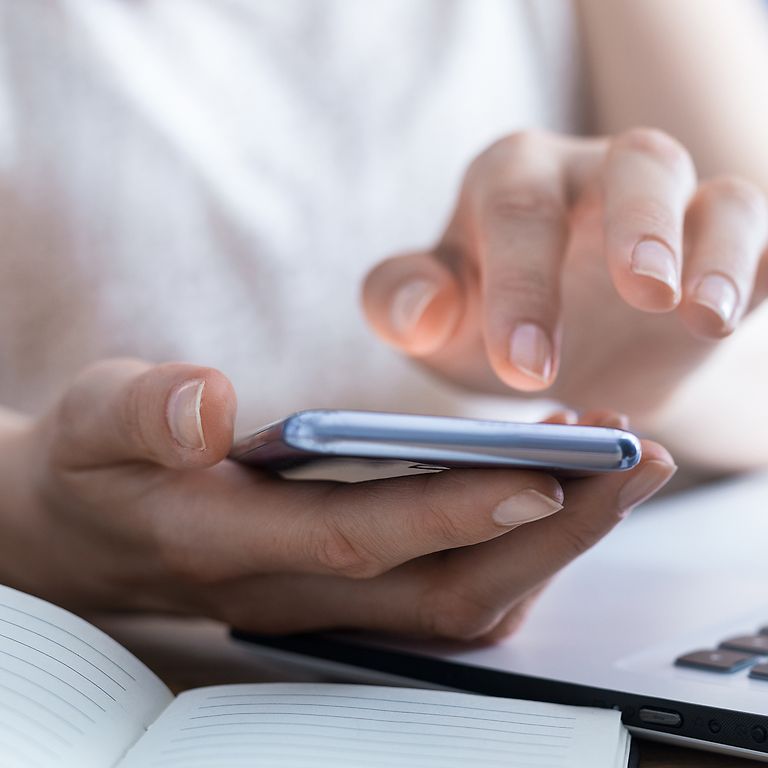 Eine Hand tippt eine Telefonnummer ein.