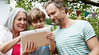 Großmutter, Vater und Sohn am Tablet-Computer.