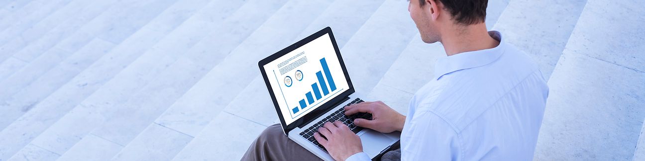 Mann mit Laptop sitzt auf Treppe