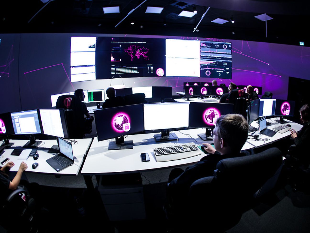 Mitarbeiter des Security Operation Center der Telekom sitzen vor ihren Monitoren