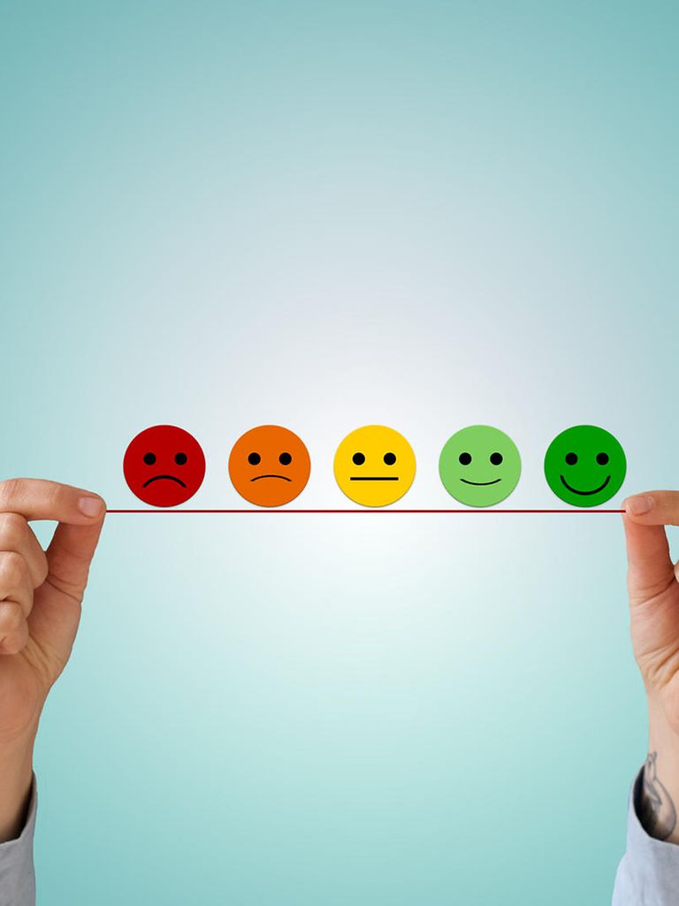 Zwei Hände halten eine fünfstufige Smiley-Skala hoch