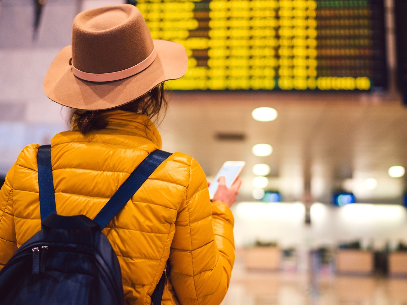 Woman looking at airport arrival times display.