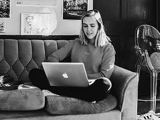 Student sitting with laptop on the sofa