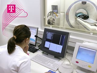 Eine Ärztin vor Bildschirmen. Im Hintergrund ist ein Patient in der Computertomographie-Röhre.