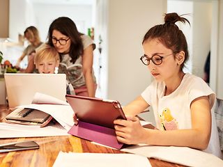 Familie beim Homeschooling am Küchentisch.