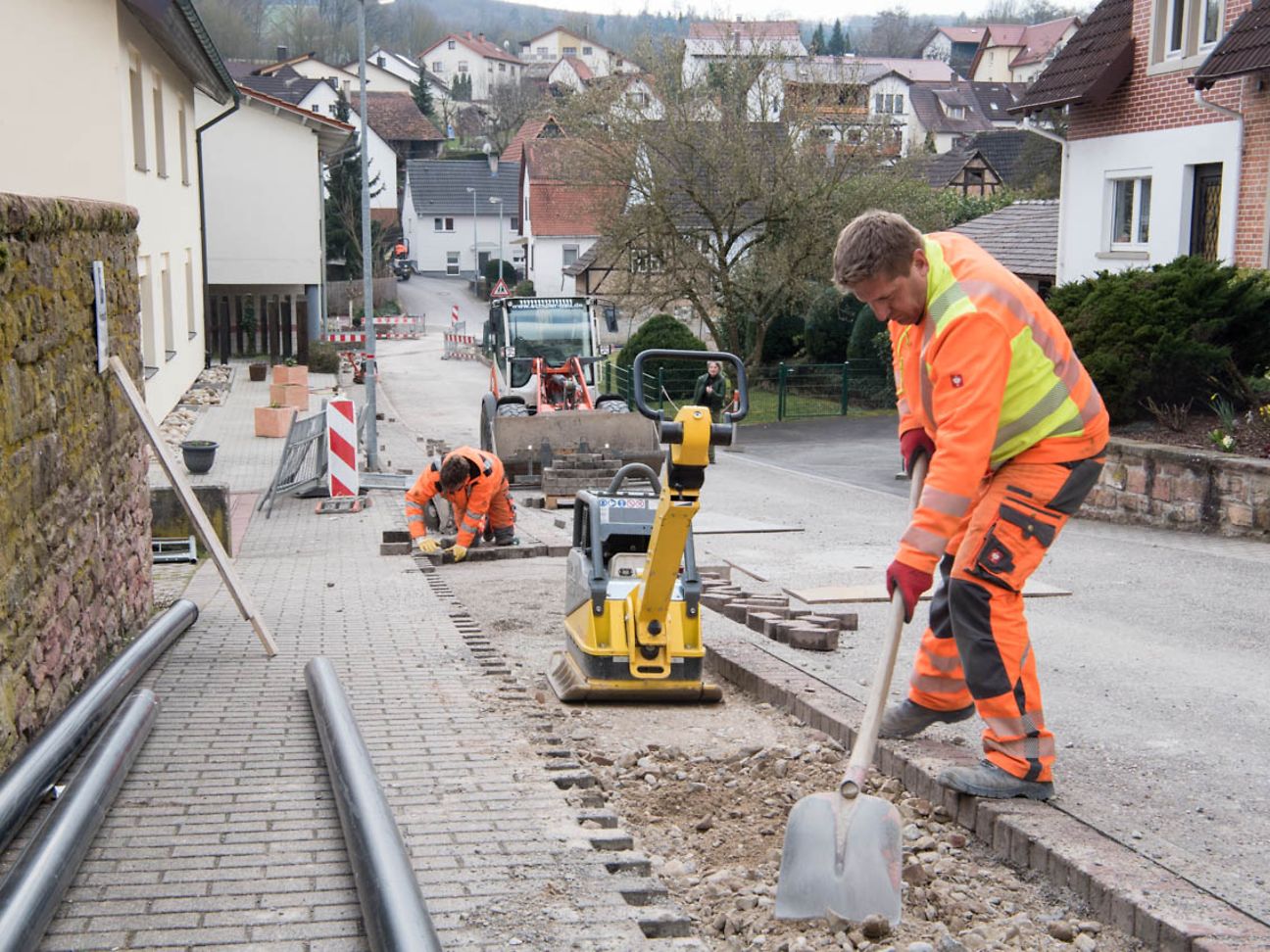 Ein Bauarbeiter verteilt Schutt in einer Baustelle.
