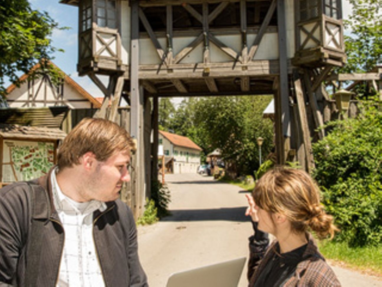 Ein Techniker mit Autorin Caroline Eichhorn vor dem Eingangstor in Kaltenberg.